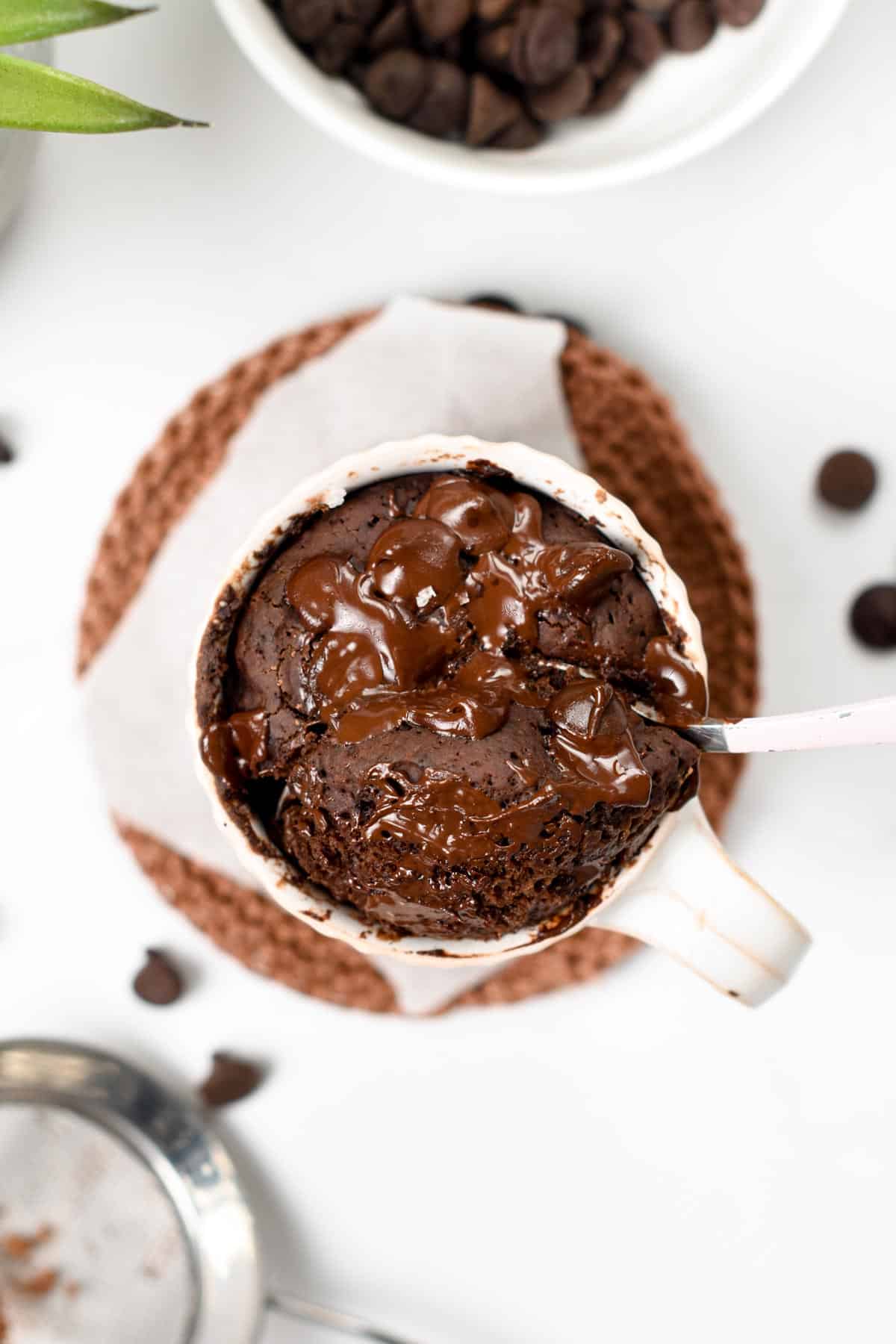 Gooey Chocolate Mug Cake with a spoon taking a portion of it.