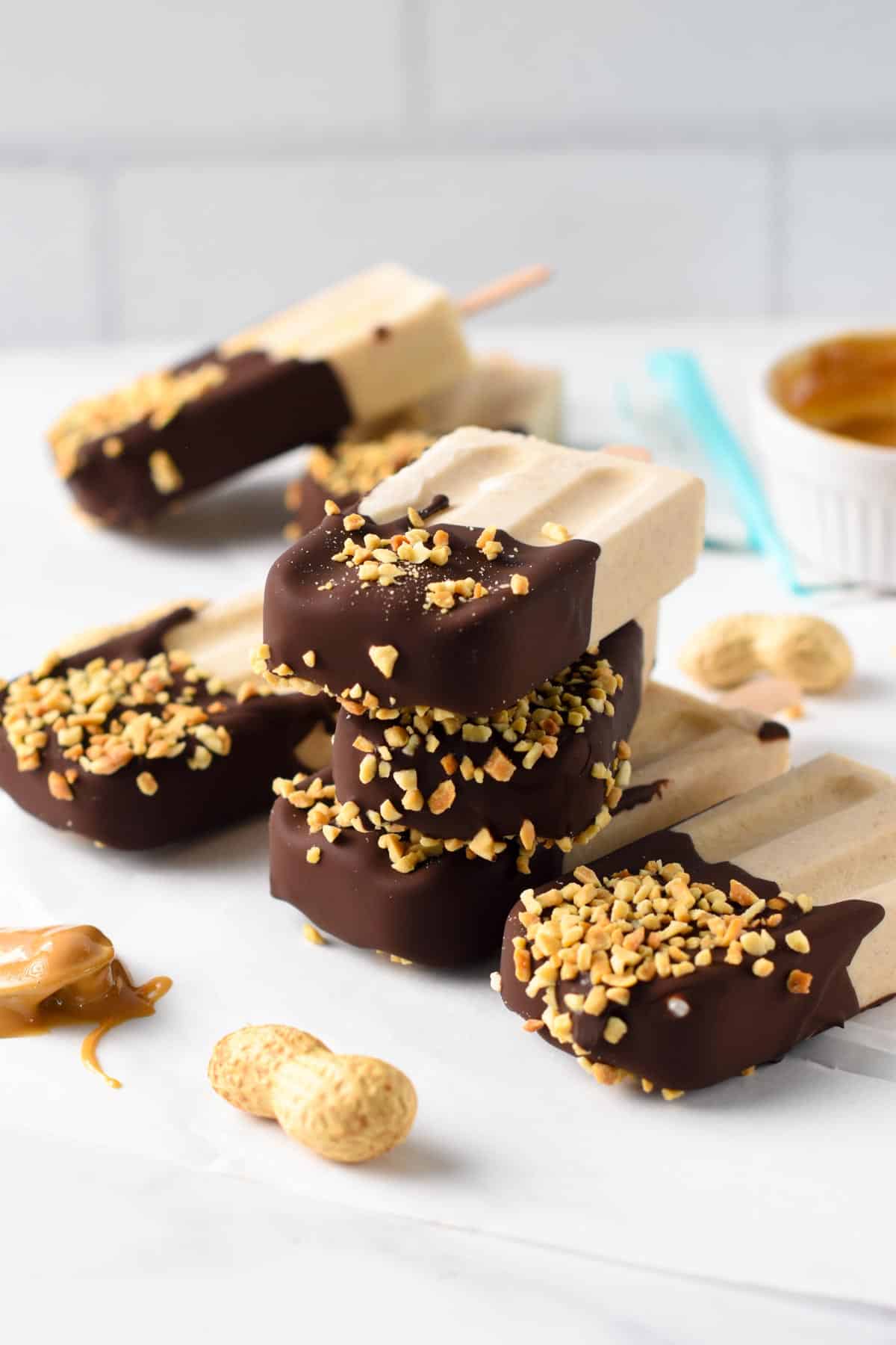 Healthy Peanut Butter Popsicles stacked on a table.