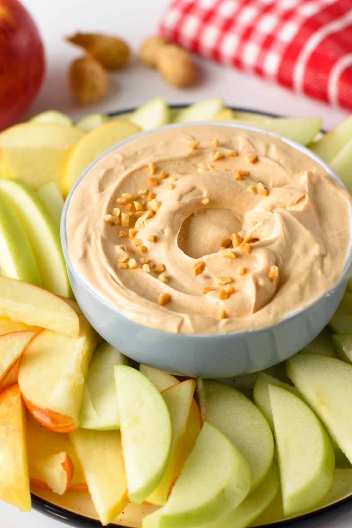 Peanut Butter Dip in a small bowl with sliced apples around.
