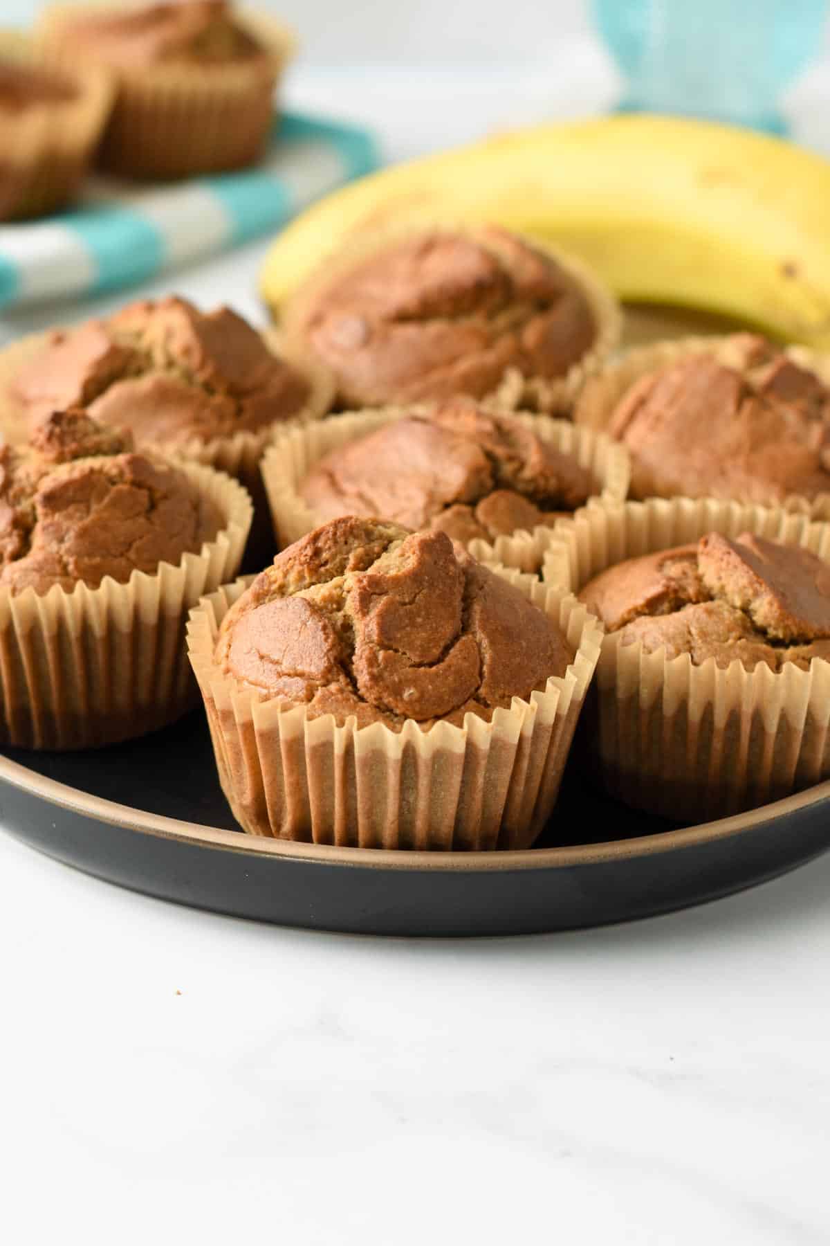 Quinoa Banana Muffins in muffin cups on a black plate.
