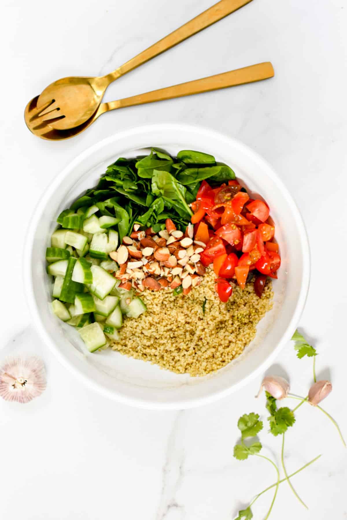 A healthy quinoa spinach salad with juicy tomatoes, crunchy almonds, and tangy lemon dressing. 