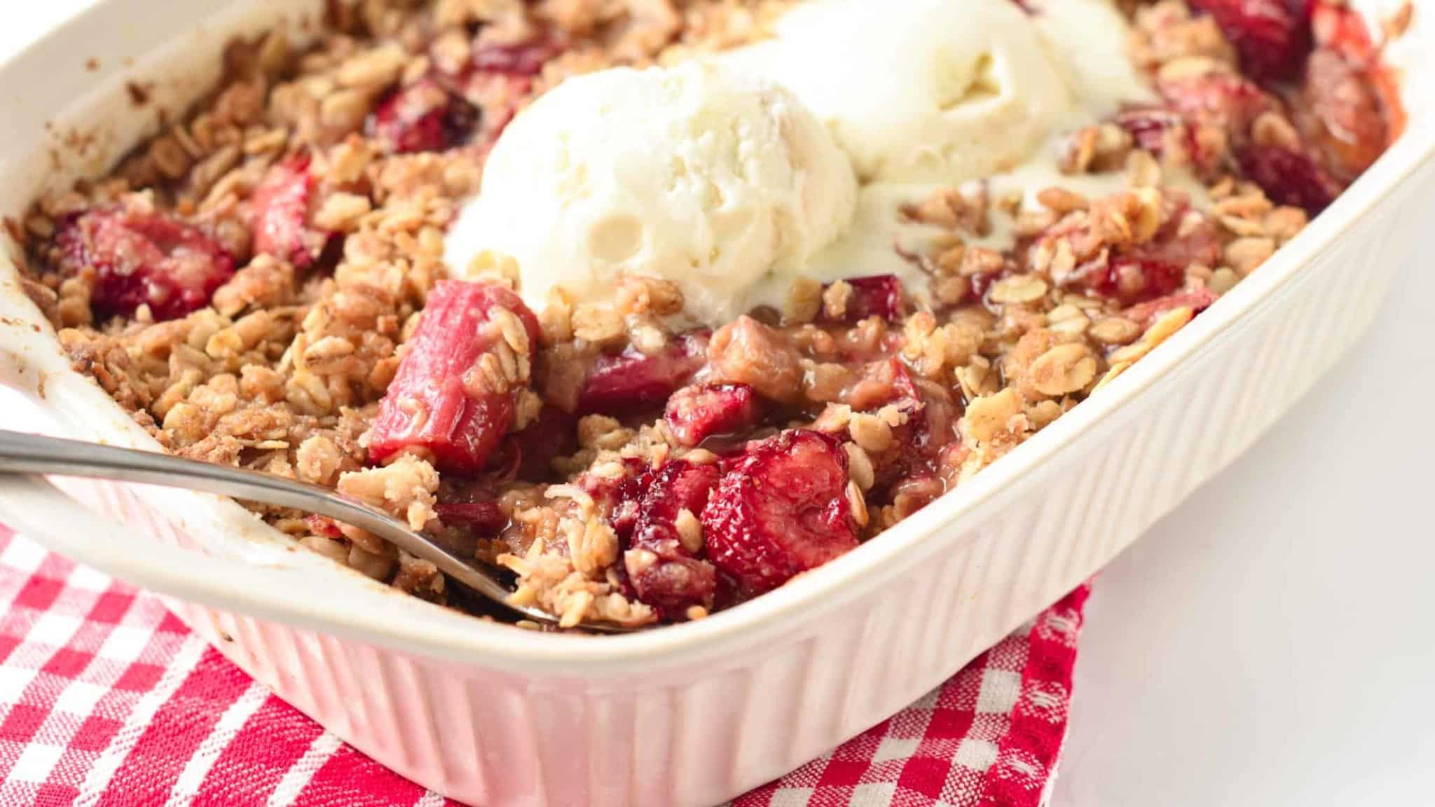 Strawberry Rhubarb Crisp on a ceramic pan with vegan ice cream.