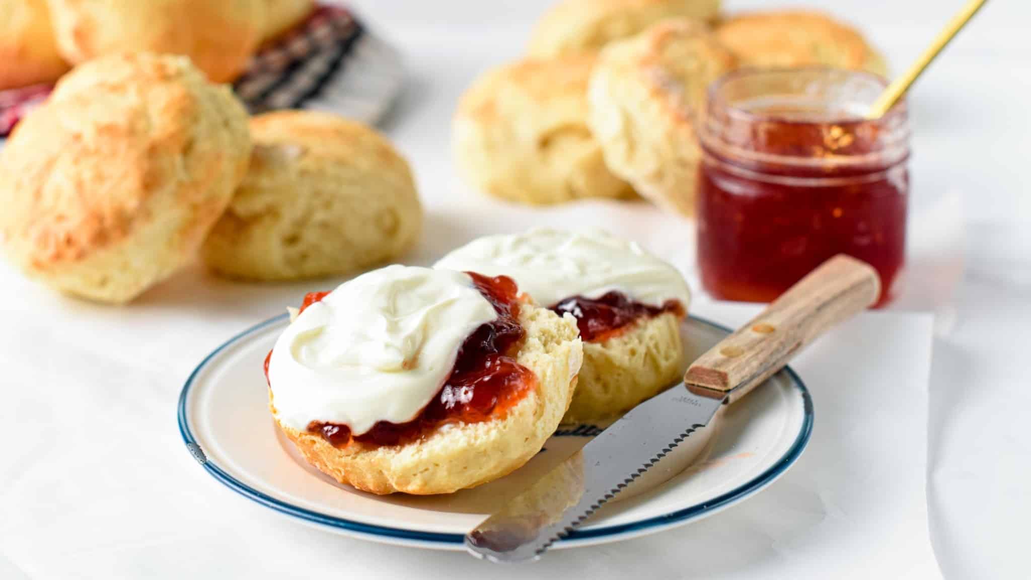 Vegan Scone Recipe cut on a plate and served with strawberry jam and vegan yogurt.