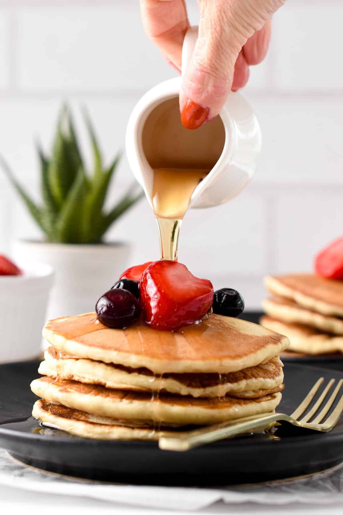 Pouring maple syrup on Low calories Pancakes