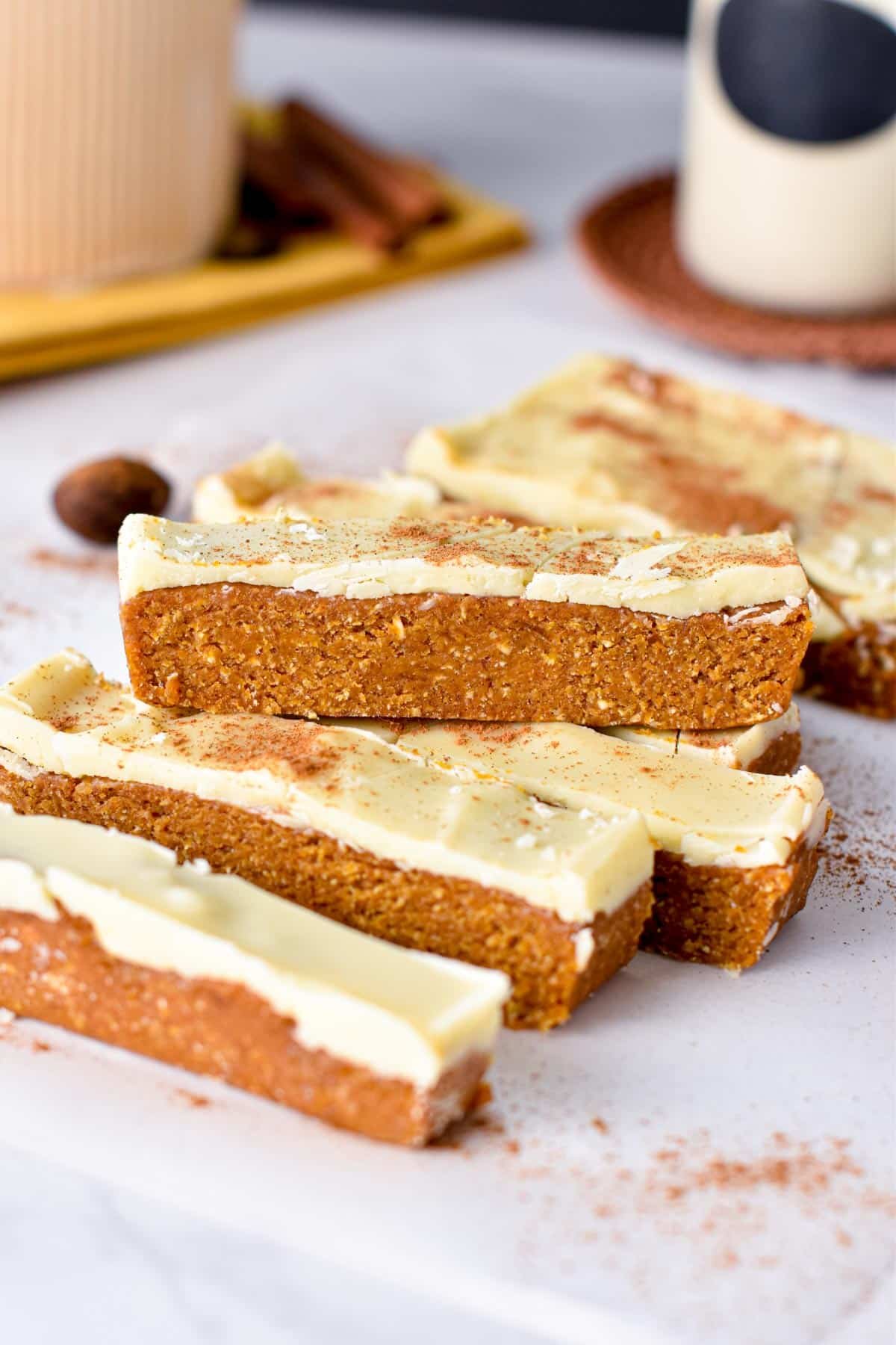 Pumpkin Protein Bars stacked on a white table.