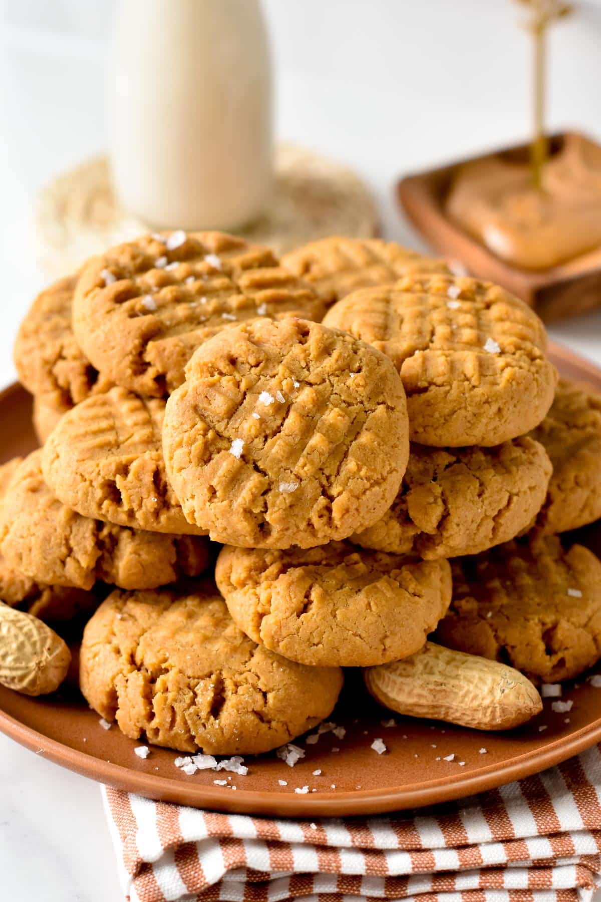 Vegan Peanut Butter Cookies stacked on a brown plate.