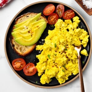 This Tofu Scramble recipe is an egg-free scramble made out tofu with such a delicious cheesy, eggy flavor that nobody will guess it's eggless.