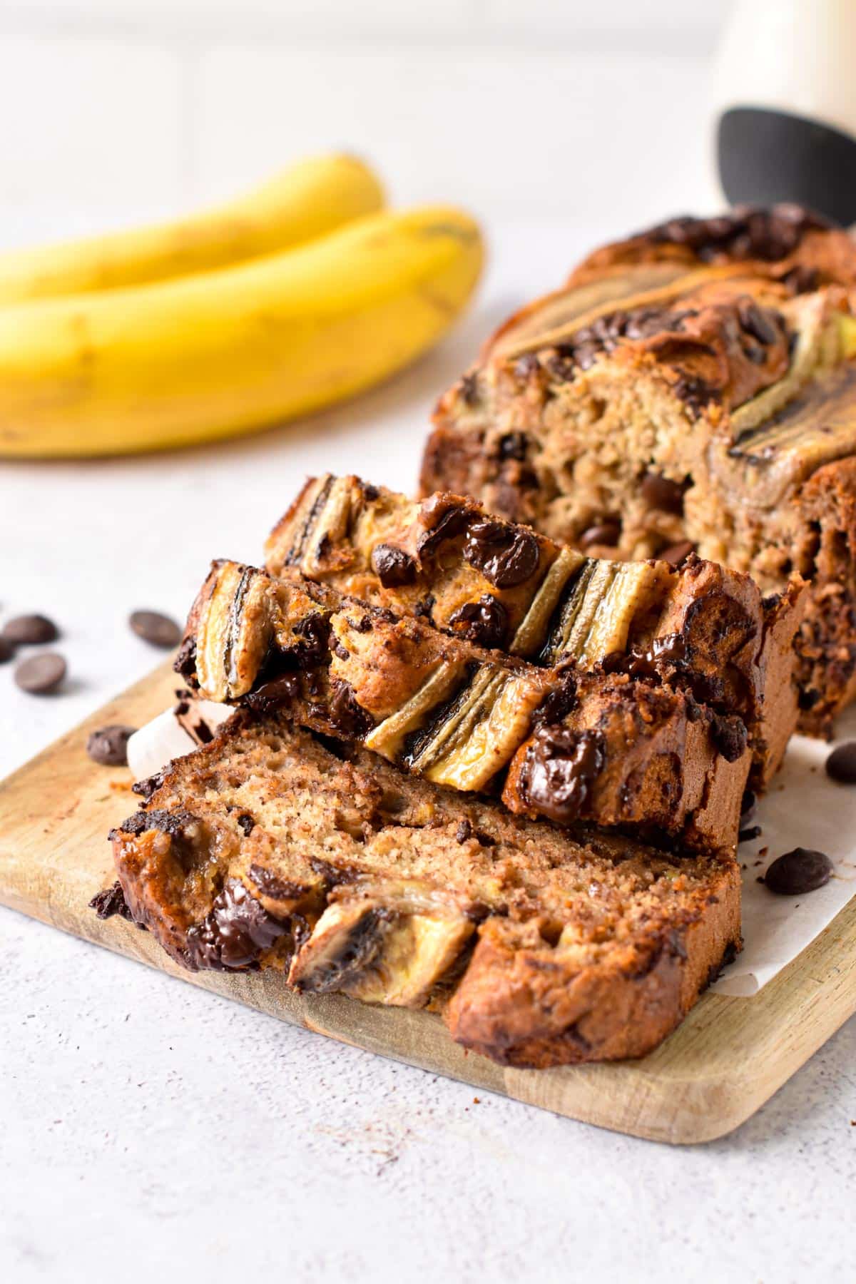 Vegan Chocolate Chip Banana Bread sliced on a chopping board.