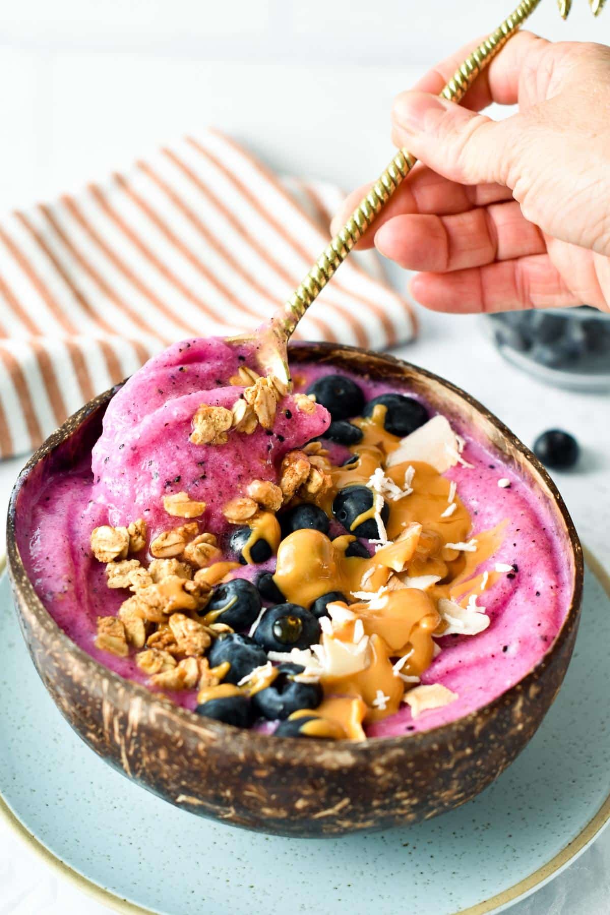 Pitaya bowl with a golden spoon digging into it.