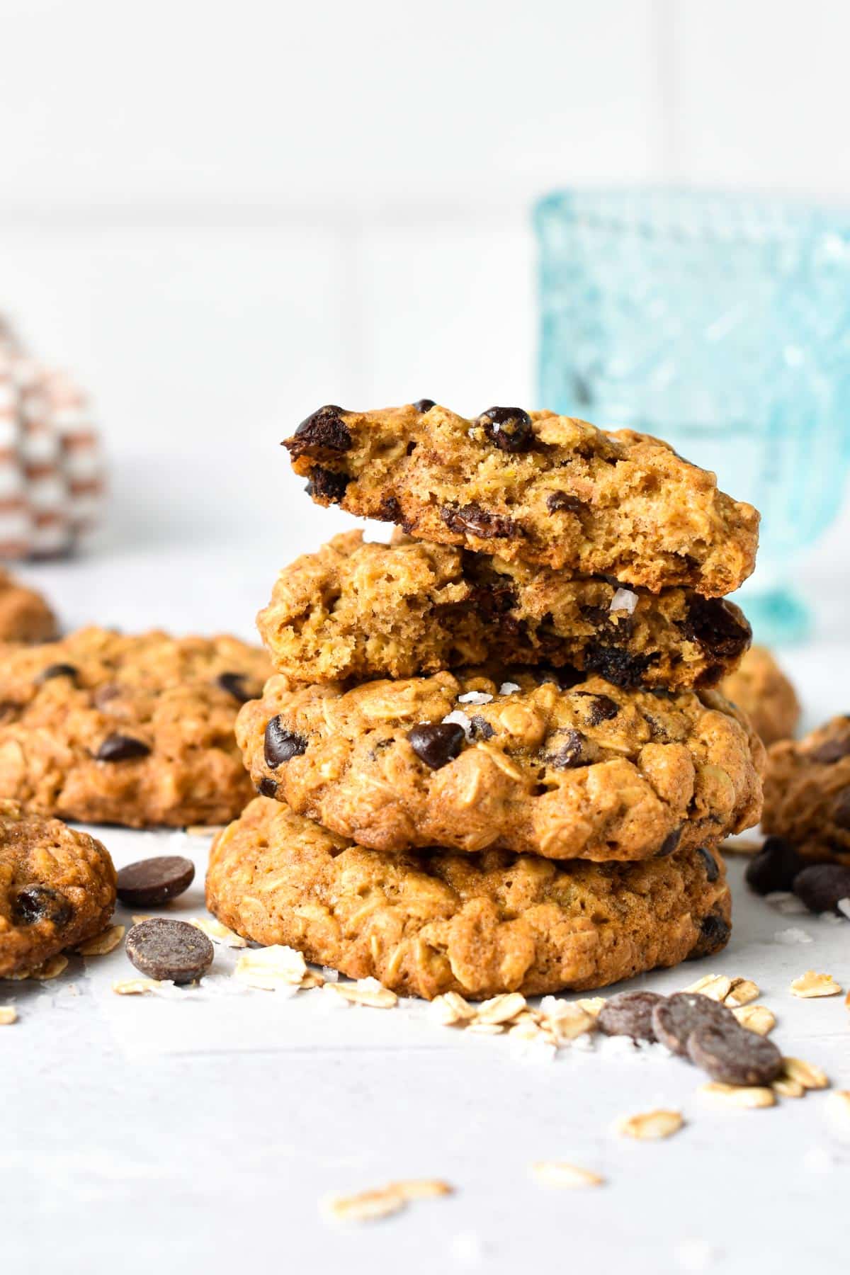 Stack of Vegan Oatmeal Chocolate Chip Cookies with chocolate chips and oats around them.