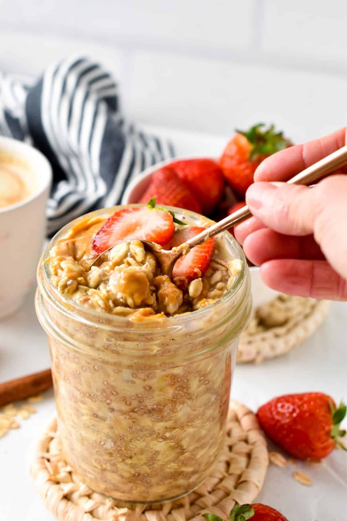 A golden spoon digging into a jar of Overnight Oats with Water.