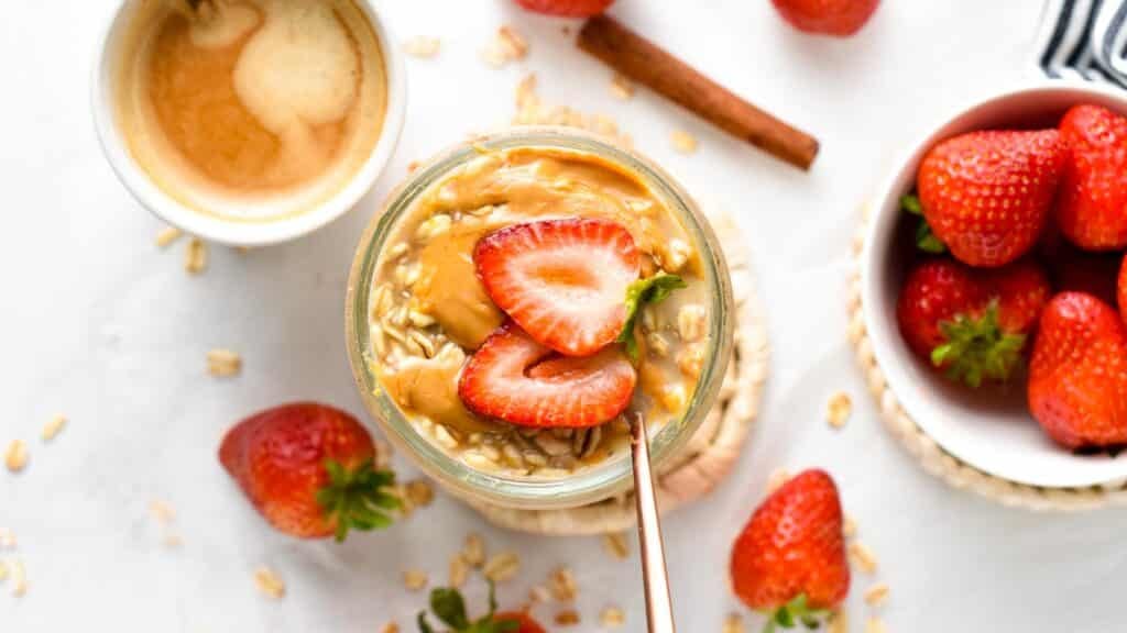 Overnight Oats with Water in a jar decorated with fresh strawberries.