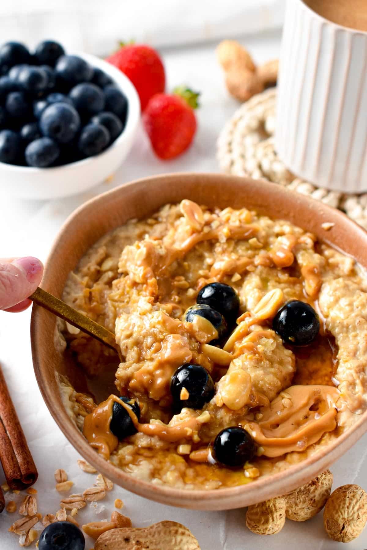 Stirring a golden spoon in a bowl of Peanut Butter Oatmeal.