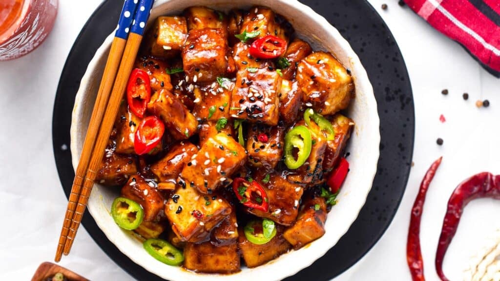 Szechuan Tofu served in a large plate with chopsticks.