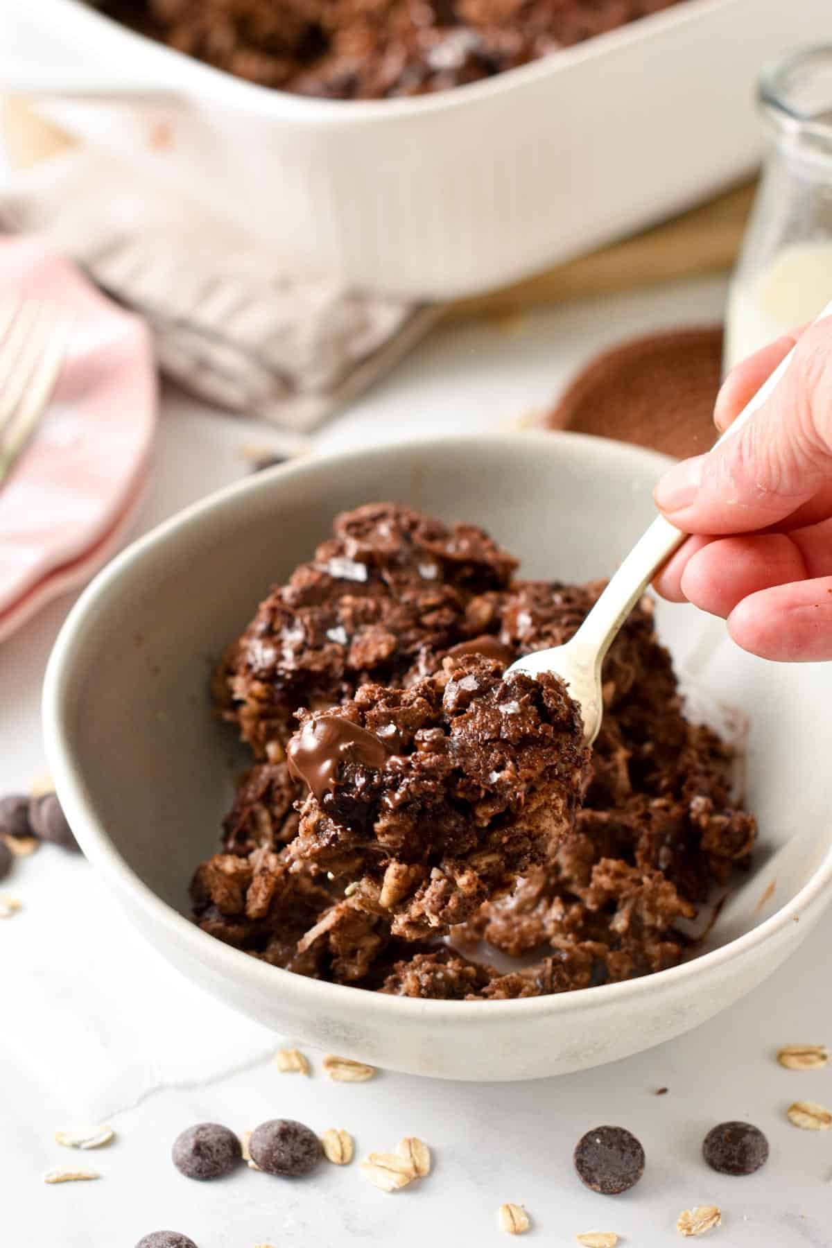 Brownie Baked Oatmeal in a bowl with a fork taking some of it.