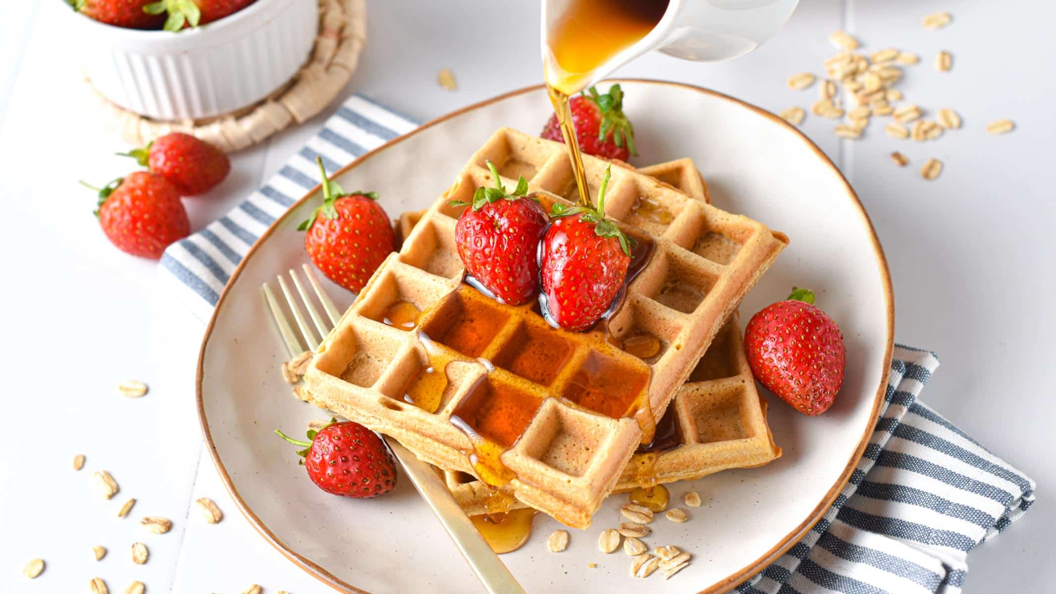 Oat flour waffles with maple syrup poured on them