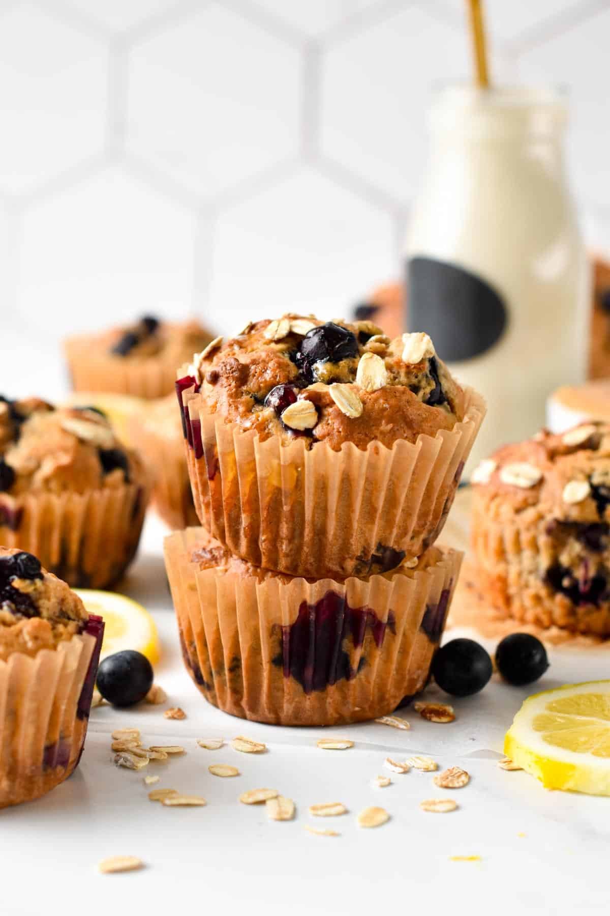 Stack of blueberry protein muffins in front of a jar with almond milk.