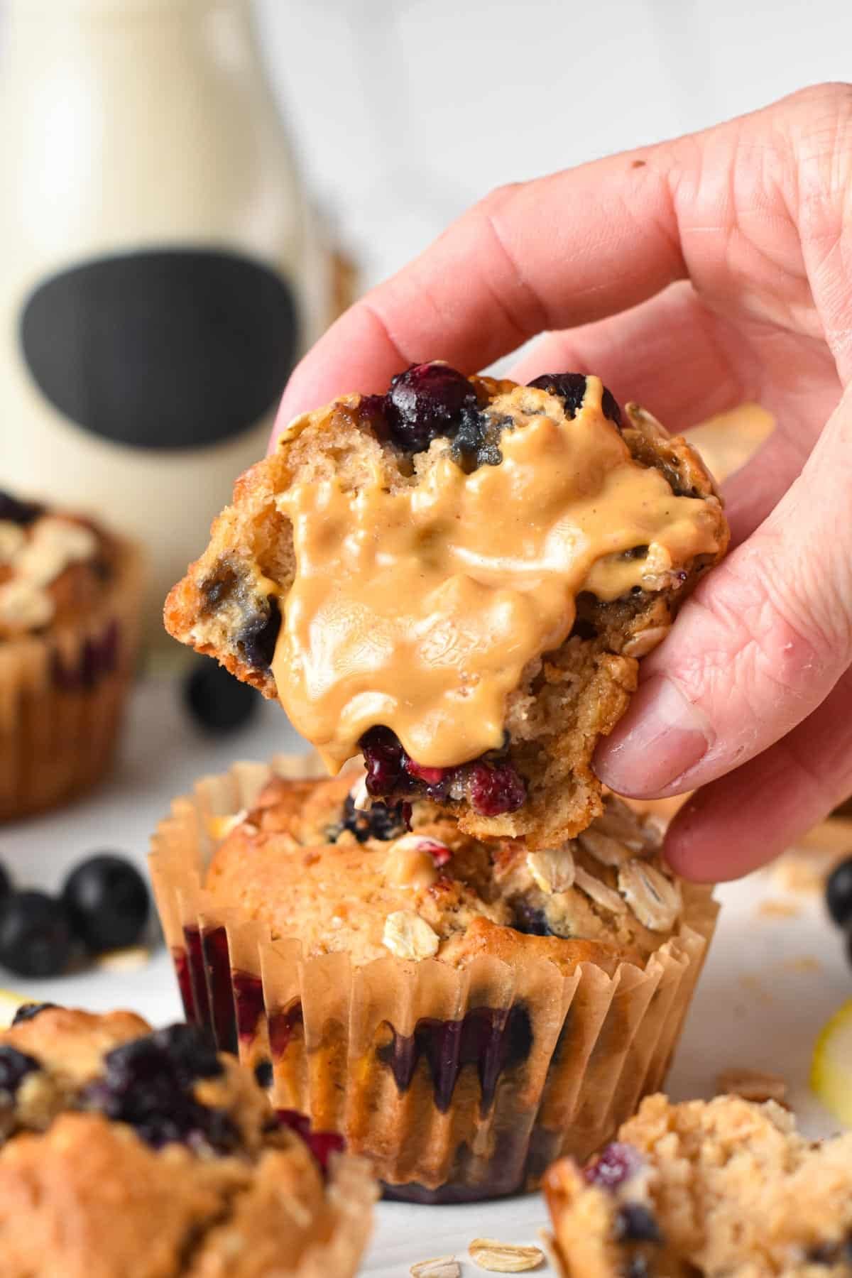 Protein Blueberry Muffins sliced in half with peanut butter spread on the inside.