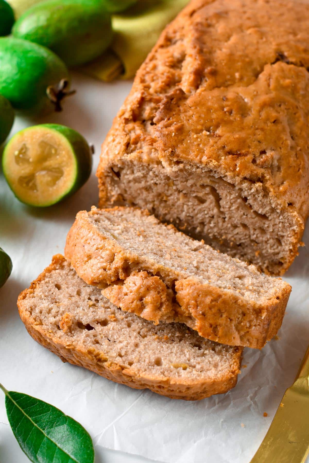 Feijoa Loaf sliced next to fresh feijoa.