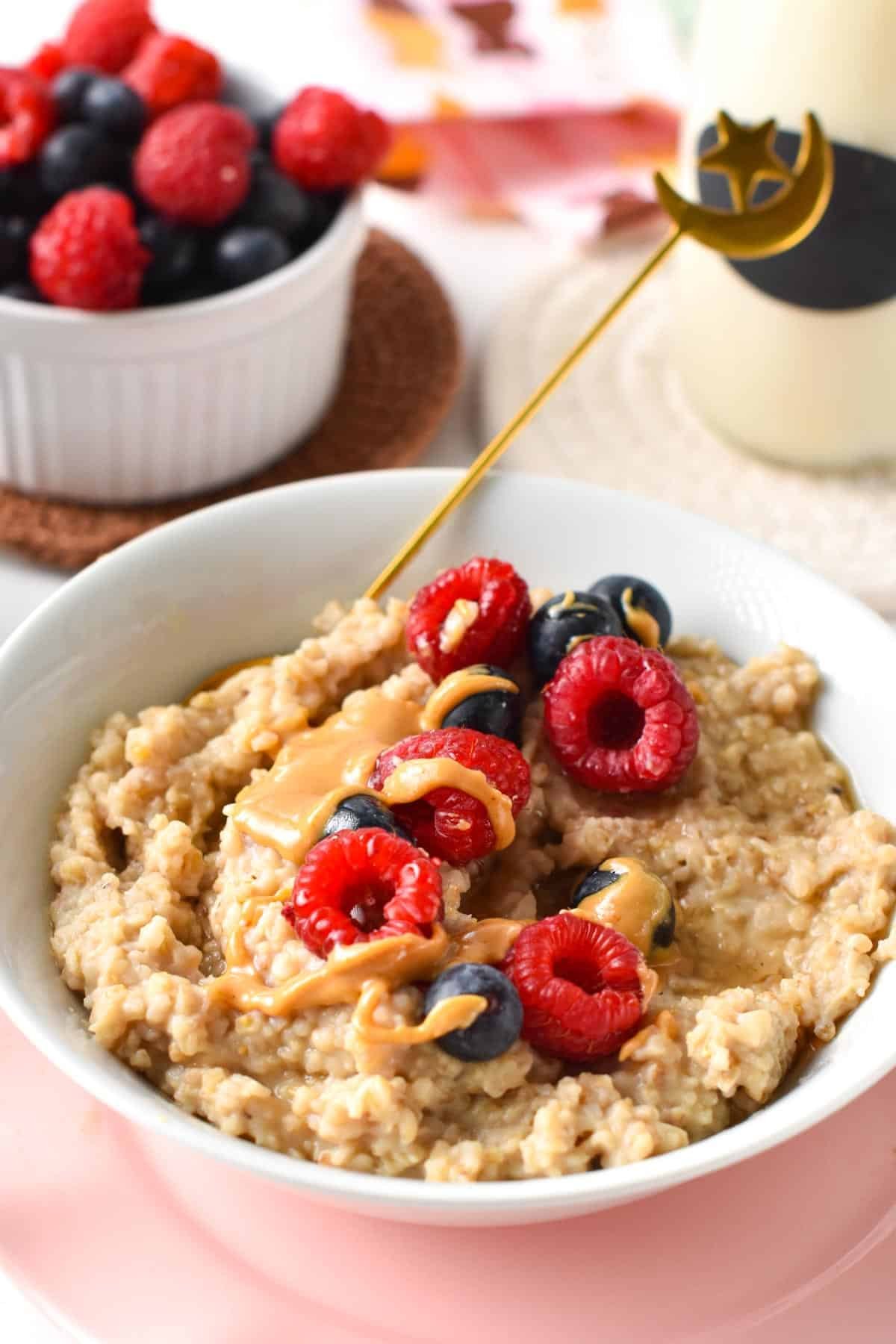 Protein Steel cut Oats served in a large bowl with fresh raspberries and blueberries