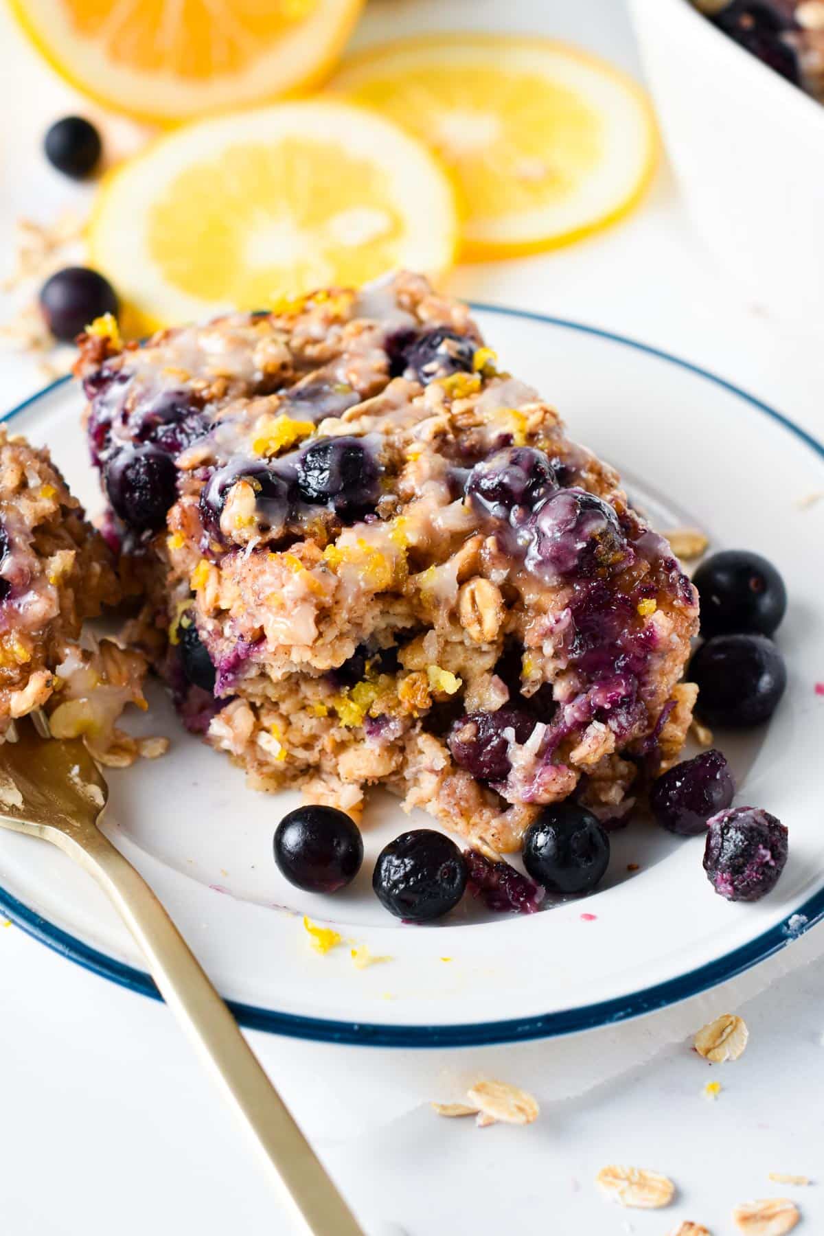 Blueberry Lemon Baked Oatmeal slice on a white plate with blue edges.