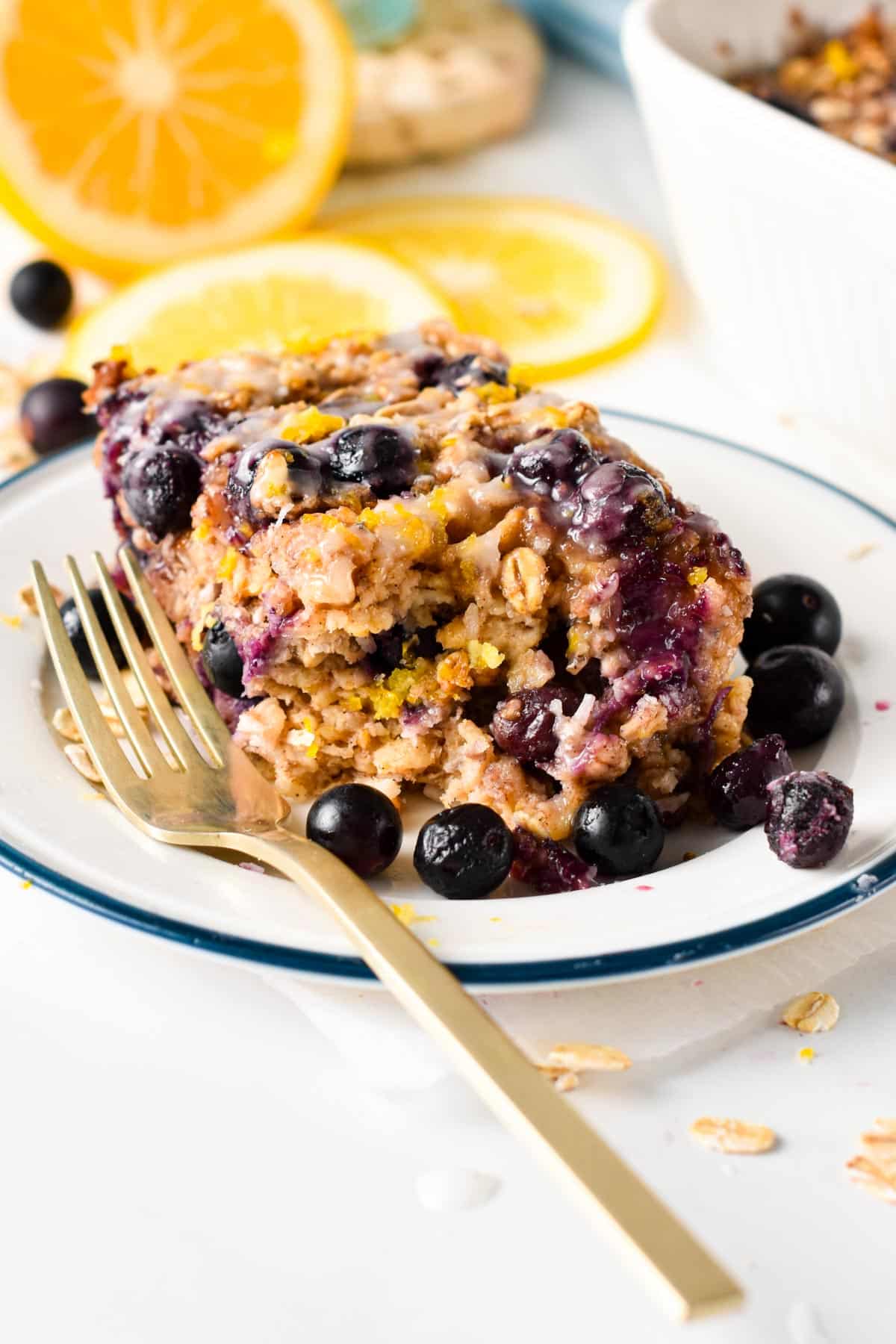Blueberry Lemon Baked Oatmeal on a plate with a golden fork.