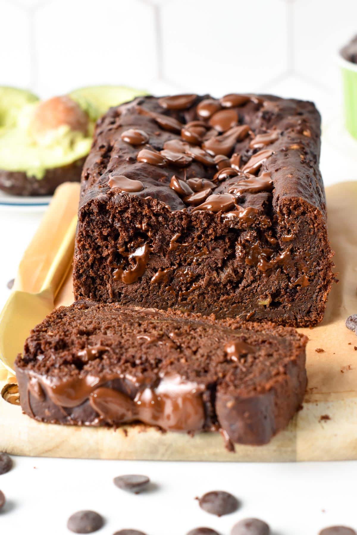 Sliced chocolate avocado bread on a wooden board.