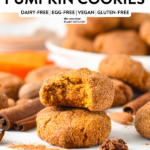 a stack of almond flour pumpkin cookies with one bitten cookie on top of the stack showing the moist pumpkin texture of the cookies