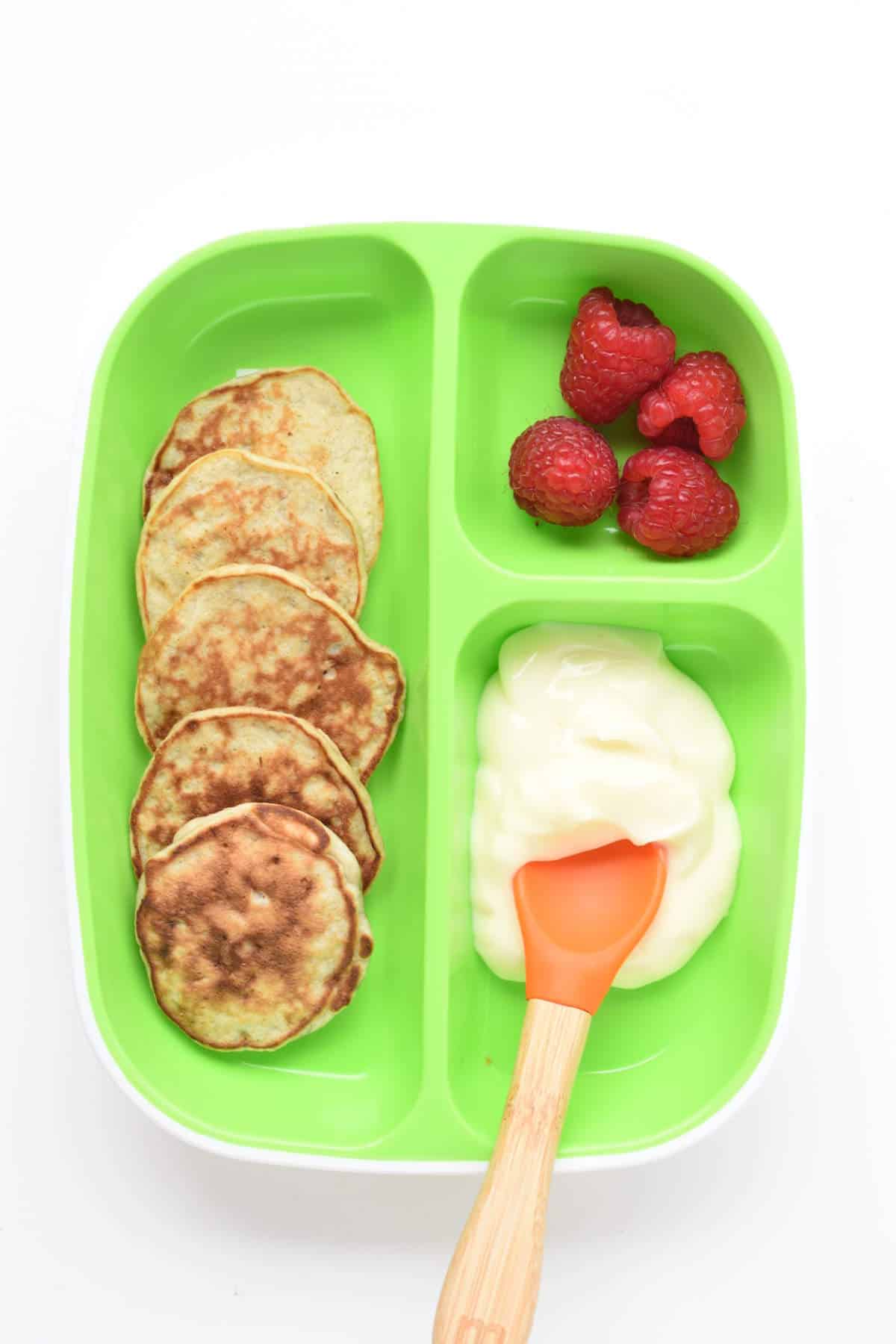 Baby Banana Pancakes On a Kid Serving Tray with vegan yogurts and raspberries