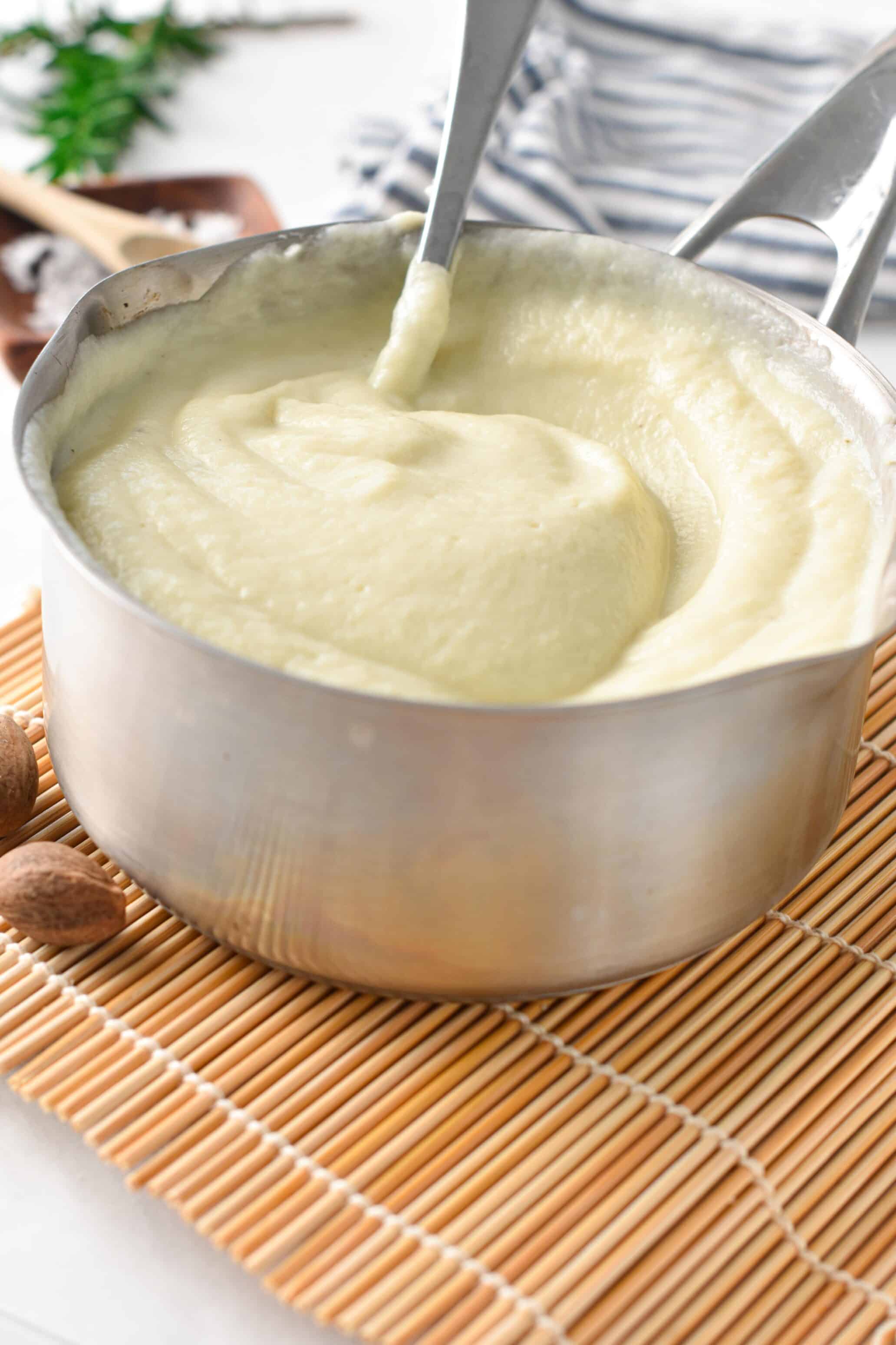 Cauliflower Bechamel sauce in a pan with a spoon