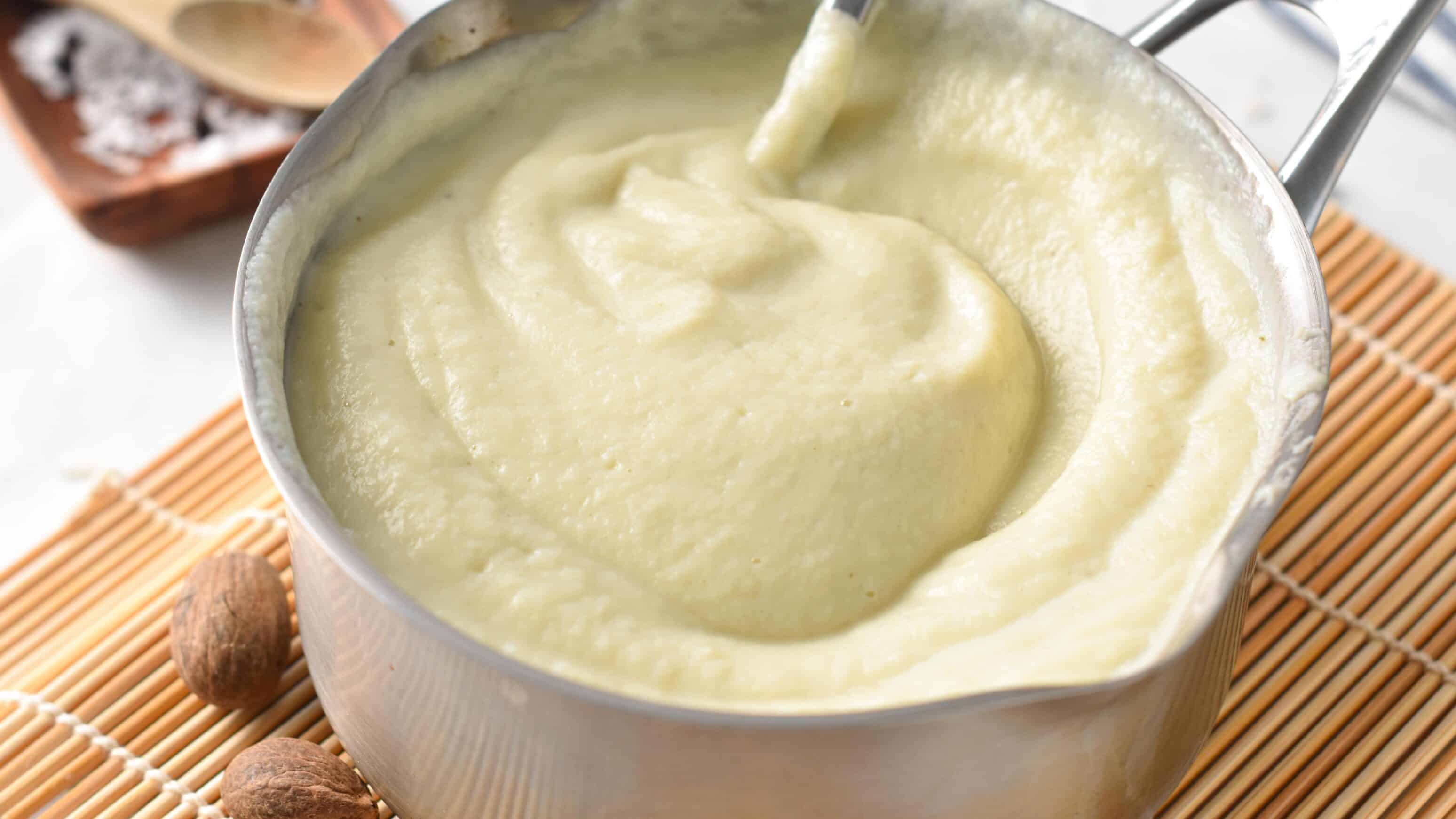 Horizontal photo of Cauliflower Bechamel sauce in a pan with a spoon