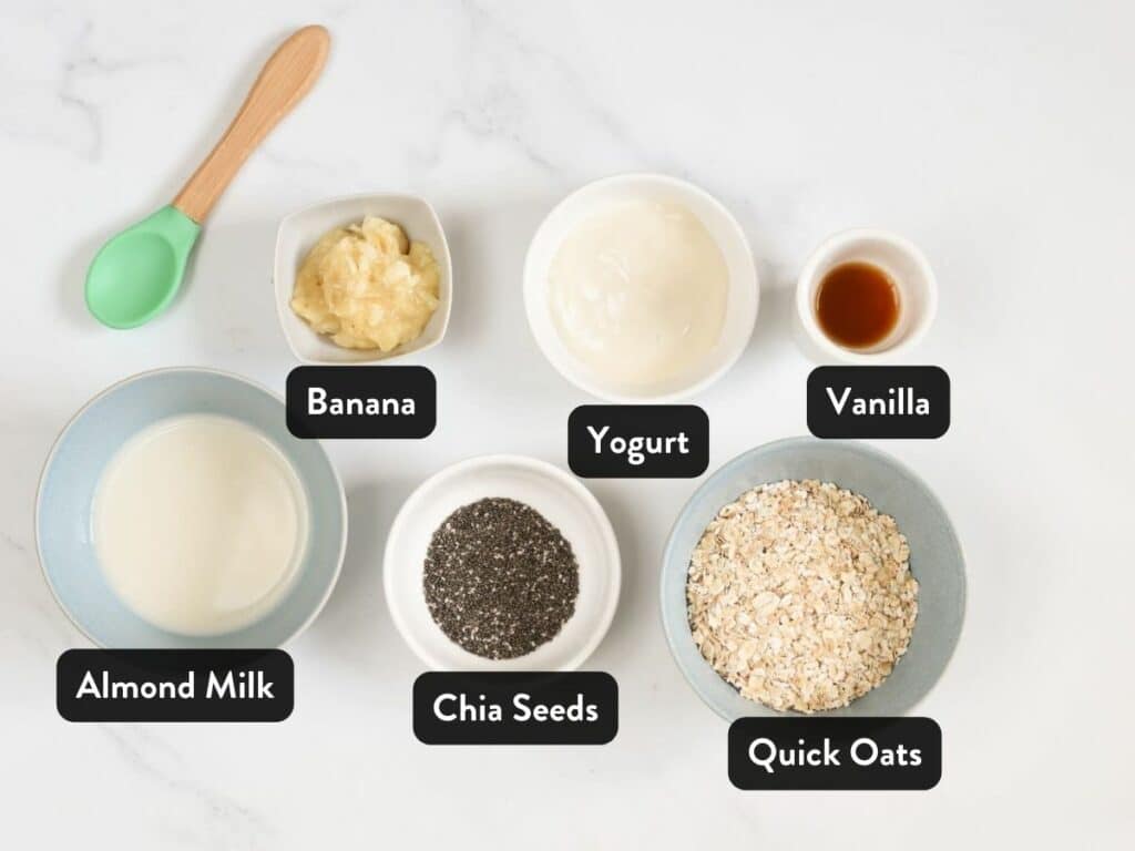 Overnight Oats For Baby Ingredients in small serving bowls next to a kid's spoon