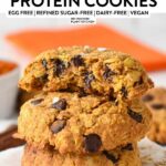 a stack of pumpkin protein cookies with chocolate chips