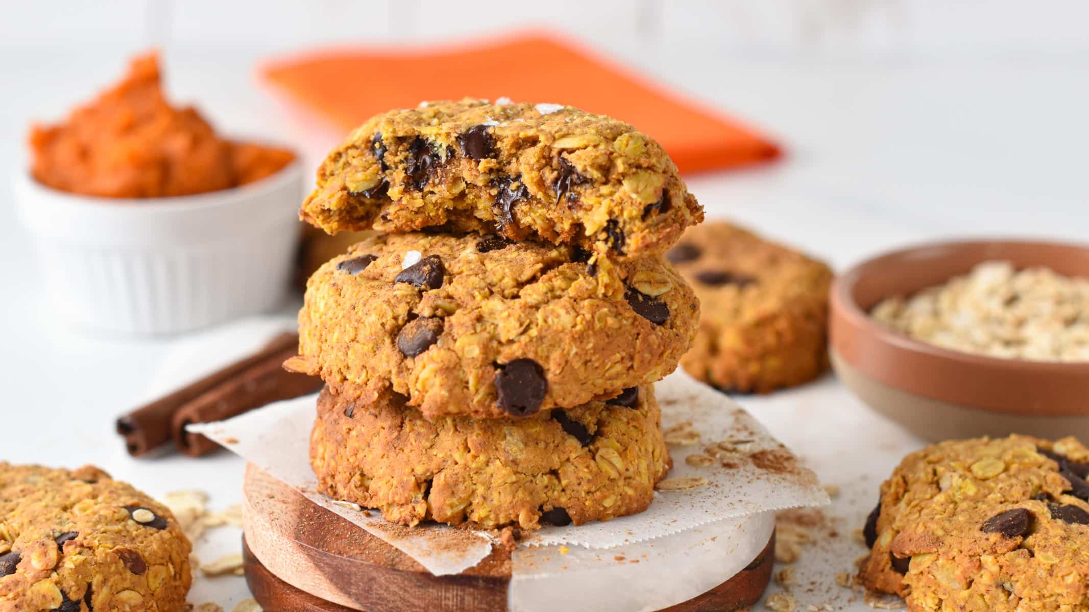 a stack of pumpkin protein cookies with chocolate chips