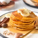 Stack of Pumpkin Protein Pancakes with sliced bananas