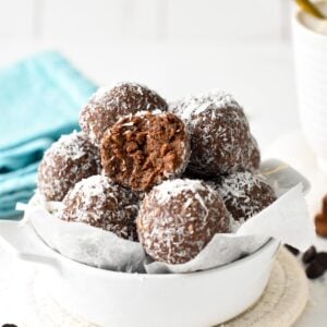 a bowl filled with chocolate coconut protein balls