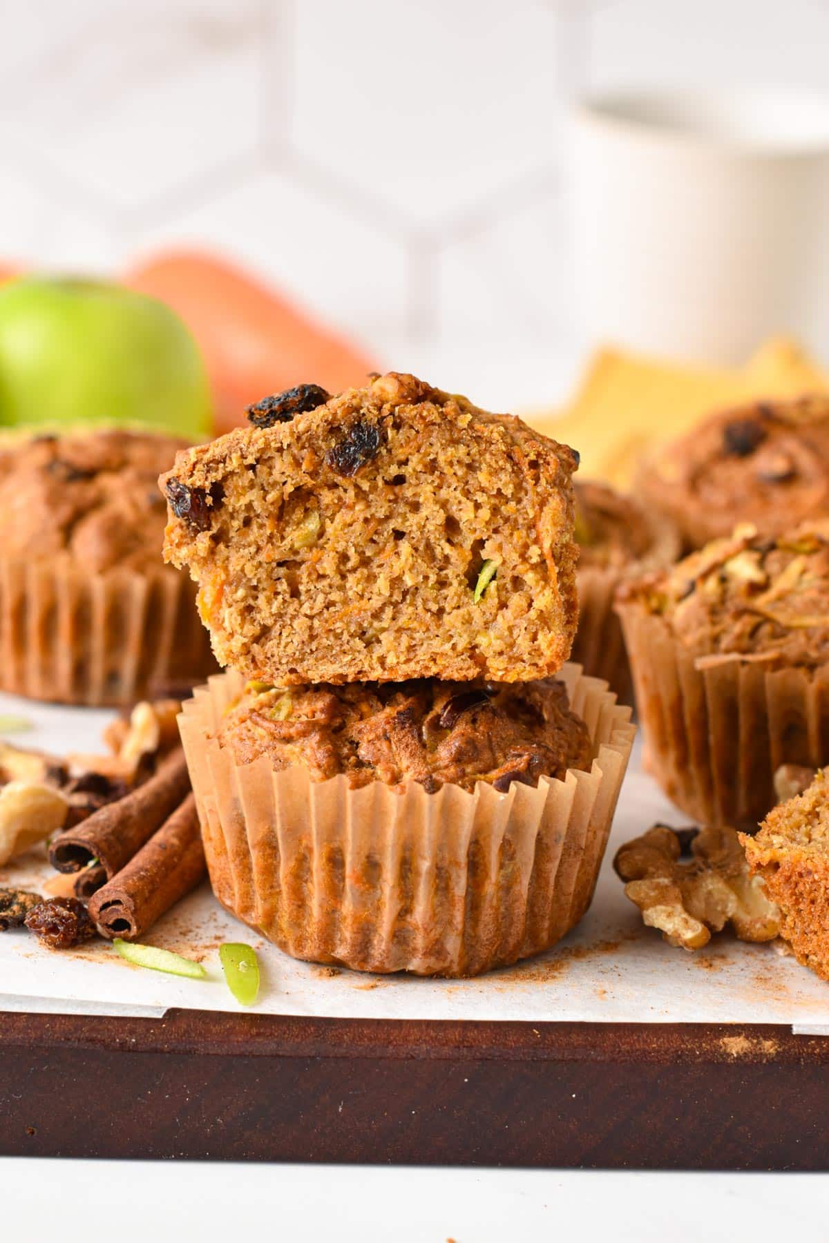 A stack of vegan Morning Glory Muffins, sliced in half and filled with carrots, raisins, and green apples.