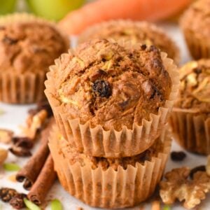 a batch of vegan Morning Glory Muffins with carrots and green apples in the background