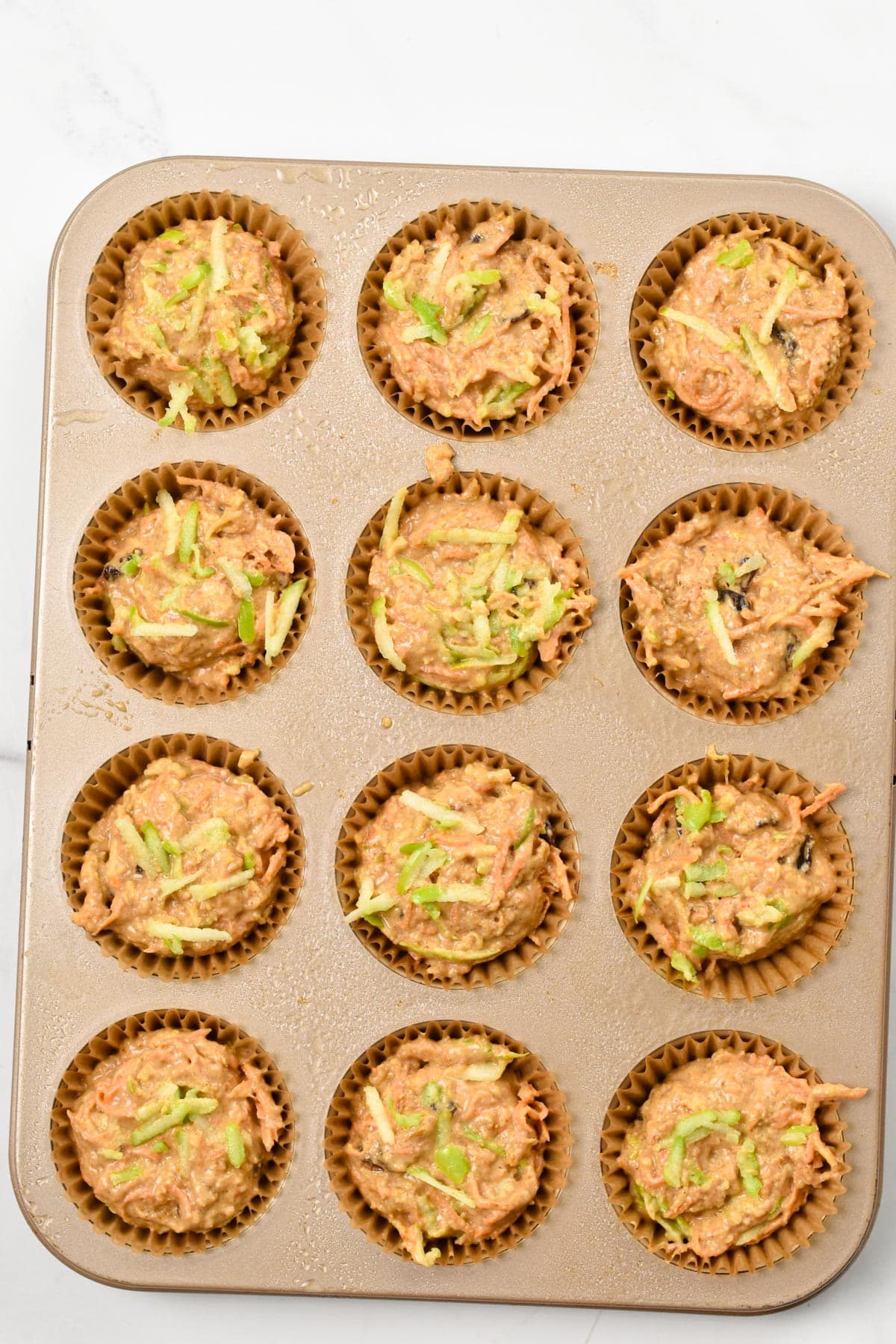 Vegan Morning Glory Muffins batter in a muffin pan