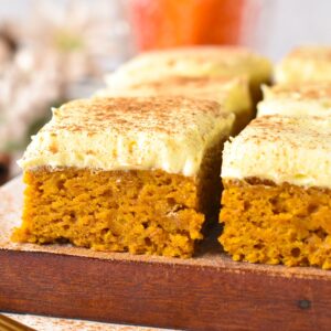 slices of vegan pumpkin bars frosted with dairy-free vanilla frosting