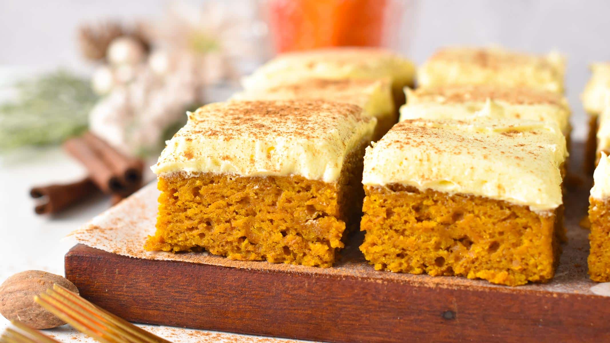 slices of vegan pumpkin bars frosted with dairy-free vanilla frosting