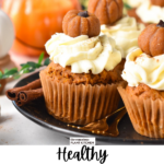 a plate filled with vegan pumpkin cupcakes frosted with vegan cream cheese frosting and little pumpkin cupcake topper