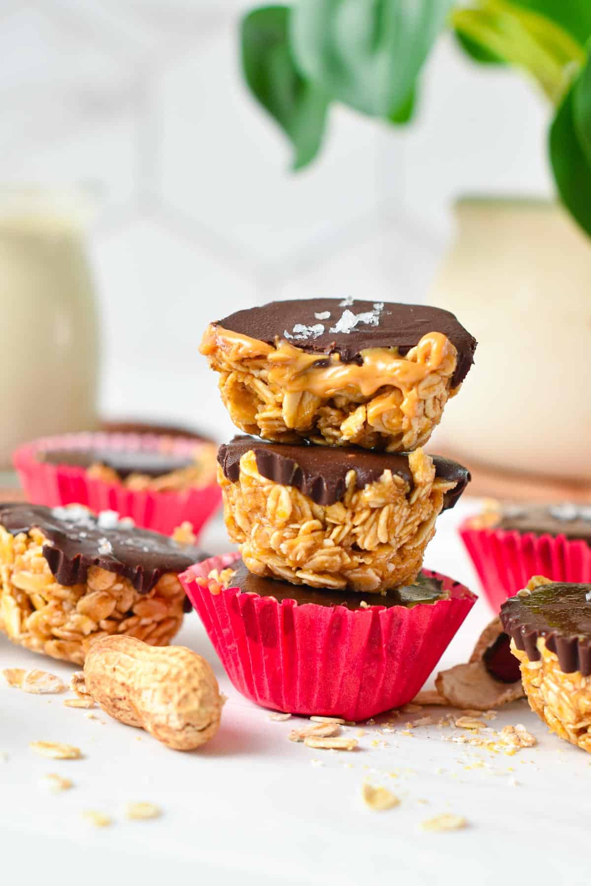 A stack of three no-bake peanut butter oat cups with the one on top half cut showing the runny peanut butter filling.
/ta