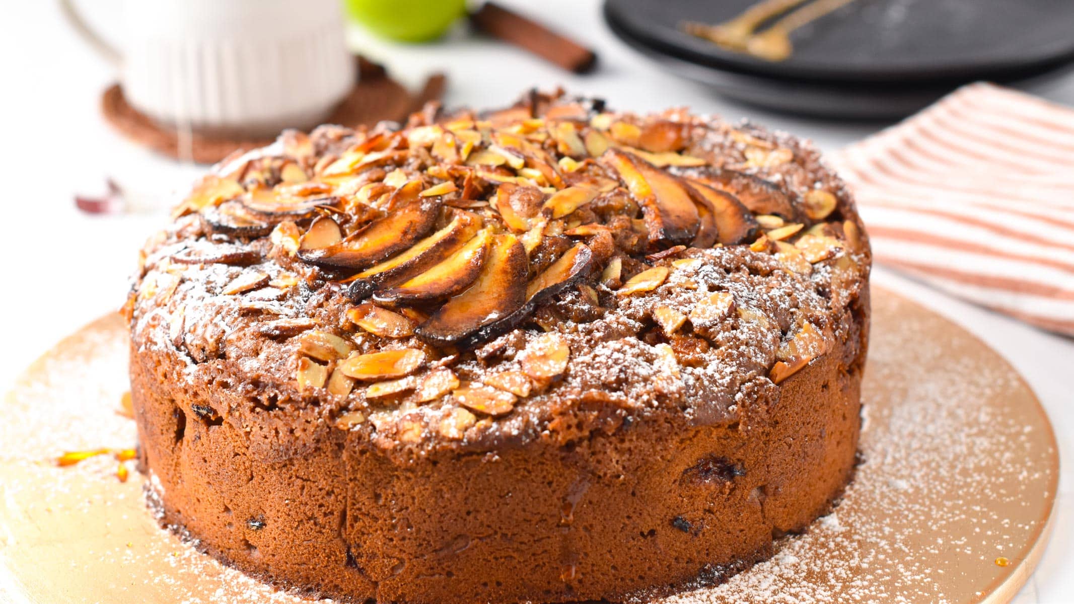 a vegan apple cake topped with sliced almonds and apple slices