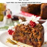 a slice of vegan Christmas cake in a plate with a golden fork