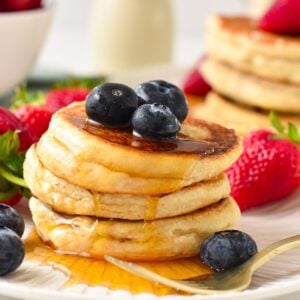 a stack of vegan coconut flour pancakes with blueberries on top