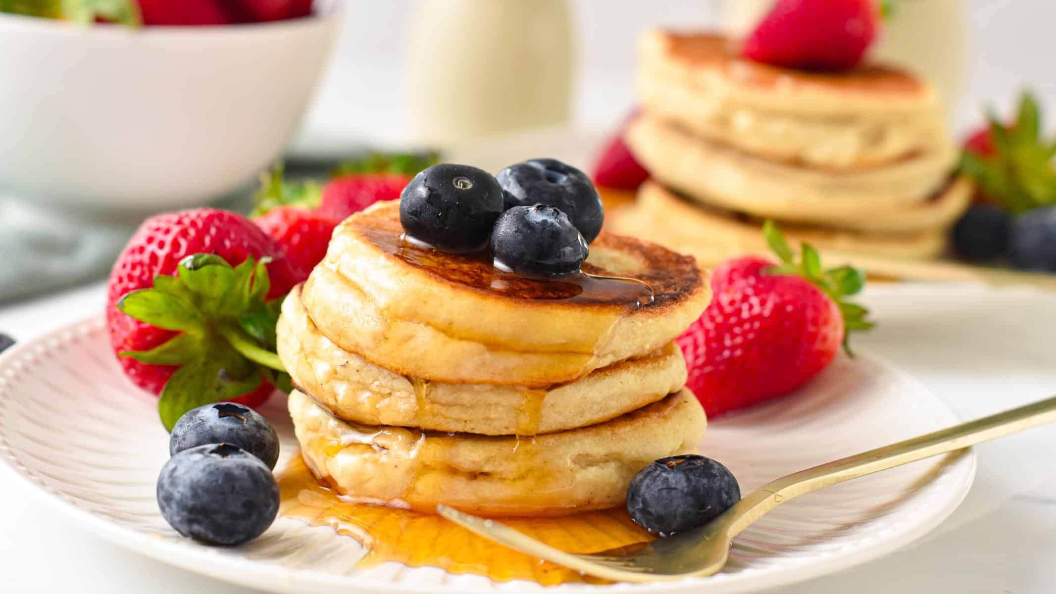 a stack of vegan coconut flour pancakes with blueberries on top