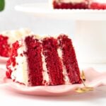 a slice of vegan red velvet cake with three layers and filled with dairy-free cream cheese frosting