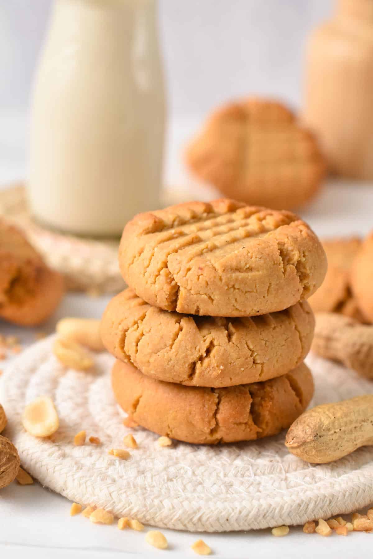 A stack of 3 Almond Flour Peanut Butter Cookies with one broken cookie on top showing the crunchy cookie texture.