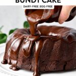 a hand pouring vegan chocolate ganache on top of a vegan chocolate bundt cake